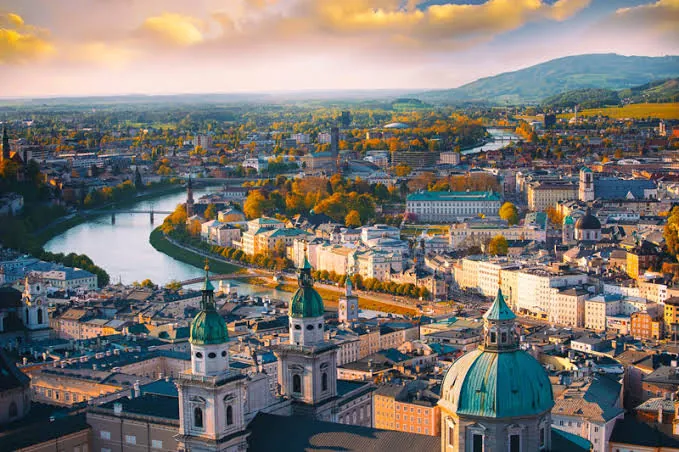 A European town beside a lake with mountains behind